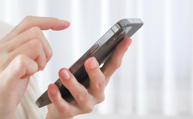 家族葬の中央区葬儀社に電話でお問合せしようとしている人の手元。